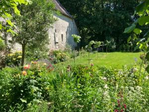 an old stone church with a garden of flowers at Château de Bagneux in Bournan