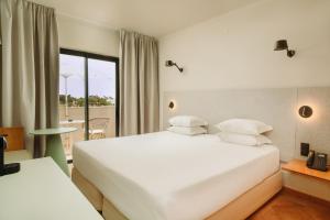 a hotel room with two beds and a balcony at Vale d'El Rei Hotel & Villas in Carvoeiro +63 photos