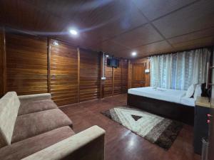 a bedroom with a large bed and a couch at Sopo Resort in Duimukh