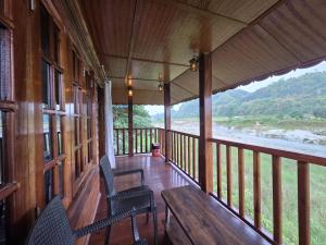a porch of a cabin with chairs and a table at Sopo Resort in Duimukh +22 photos