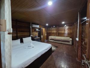 a bedroom with a bed and a couch in a room at Sopo Resort in Duimukh