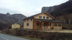 a wooden house on the side of a road at Cabana Relax Time in Vălişoara