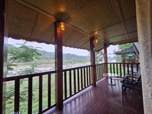 a room with a balcony with a view of the water at Sopo Resort in Duimukh
