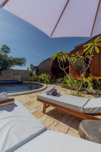a pool with two beds next to a house at Two Sisters Villa with Pool - Sire in Tanjung