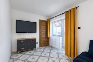 a living room with a tv and a window at Apartament pod gruszą in Legbąd