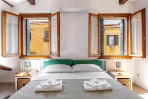 a bedroom with a bed with two towels on it at Erbe Canal View Private House in Venice
