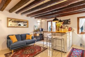 a living room with a blue couch and a kitchen at Erbe Canal View Private House in Venice
