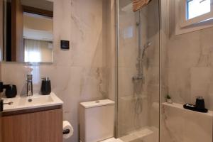 a bathroom with a shower and a toilet and a sink at Maistrali Luxury Living in Ouranoupoli