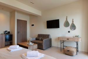 a living room with a couch and a television at Maistrali Luxury Living in Ouranoupoli