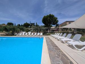 a row of white lounge chairs and a swimming pool at Agriturismo Case al Sole in Loreto