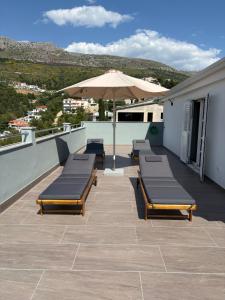 a patio with benches and an umbrella on a roof at Bellavista in Strožanac