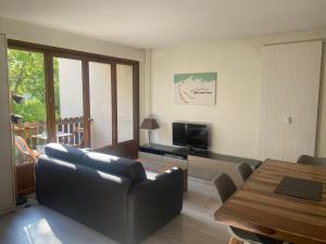a living room with a couch and a table at Résidence du parc in Briançon