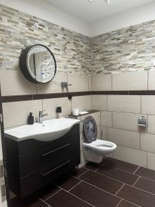 a bathroom with a sink and a toilet and a mirror at Ferienwohnung Fatlume No 4 in Bad Honnef am Rhein