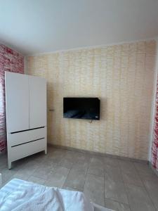 a bedroom with a white cabinet and a wall with a fireplace at Ferienwohnung Fatlume No 4 in Bad Honnef am Rhein +3 photos