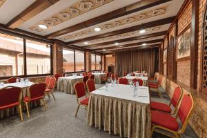 a dining room with tables and chairs and windows at Ichan Qal'a Premium Class Hotel in Tashkent +90 photos