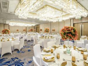 a large banquet hall with white tables and white chairs at Admiral Hotel Manila - MGallery Collection in Manila +148 photos