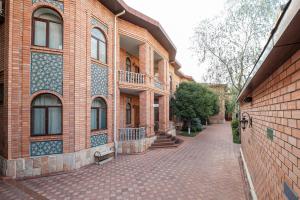 a brick building with a cobblestone street in front at Ichan Qal'a Premium Class Hotel in Tashkent