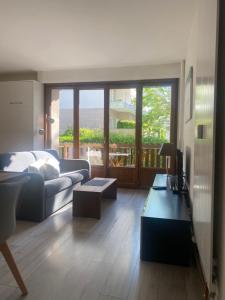 a living room with a couch and a table at Résidence du parc in Briançon