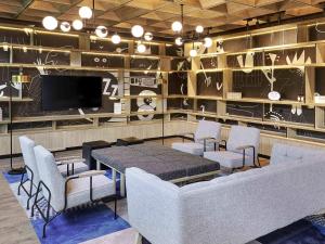 a dining room with a table and chairs and a tv at Ibis Samarinda in Samarinda