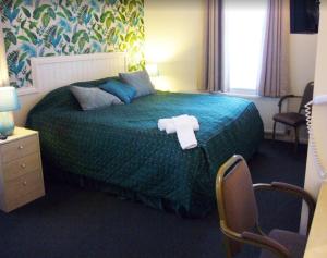 a hotel room with a bed with a towel on it at Marmion House Hotel in Wisbech
