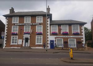 a man is standing in front of a building at Marmion House Hotel in Wisbech