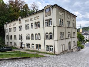 a large white building with many windows on a street at Gipfelglück Sebnitz Apartment in Sebnitz