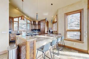 a large kitchen with a large island with chairs at The Gold Flake Chalet in Breckenridge