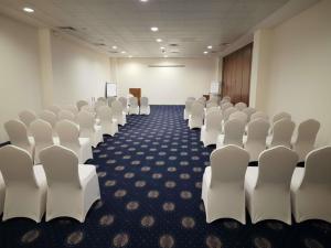 a conference room with white chairs and a podium at Naama Bay Promenade Beach Resort Managed By Accor in Sharm El Sheikh +199 photos
