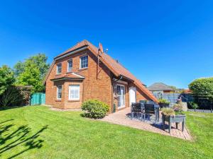 a brick house with a roof on a lawn at Wolles Sonnenhaus in Wirdum