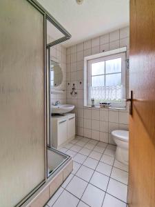a bathroom with a shower and a toilet and a sink at Wolles Sonnenhaus in Wirdum +21 photos