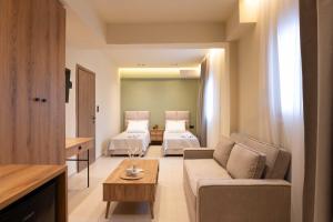 a living room with two beds and a couch at Maistrali Luxury Living in Ouranoupoli