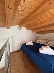 a bedroom with a blue bed with wooden ceilings at Veterani House 33 in Cefalù
