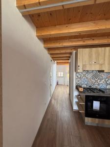 a kitchen with white walls and wooden ceilings at Veterani House 33 in Cefalù +6 photos