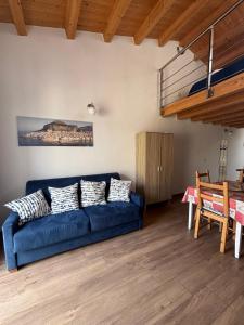 a living room with a blue couch and a table at Veterani House 33 in Cefalù