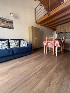 a living room with a blue couch and a table at Veterani House 33 in Cefalù