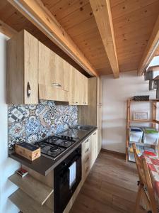 a kitchen with wooden cabinets and a stove top oven at Veterani House 33 in Cefalù
