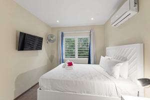 a white bedroom with a white bed and a window at Casa Verde - Blije Rust I in Dorp Sint Michiel