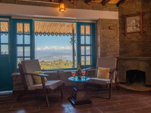 a living room with a fireplace and a table and chairs at Dharohar Retreat, Mukteshwar in Mukteshwar +179 photos