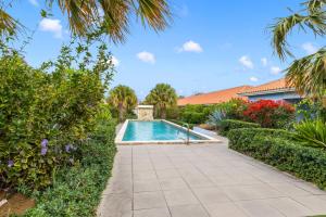 a swimming pool in a garden with bushes at Casa Verde - Blije Rust I in Dorp Sint Michiel