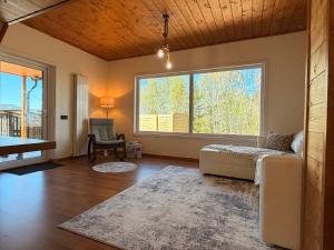 a living room with a couch and a large window at Sunset Mountains Village in Dealu Negru