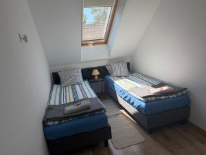 two twin beds in a room with a window at Apartamenty Dana in Pustkowo