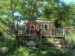 a log cabin with a deck and a tree at Mobile homes a la ferme in Ille-sur-Têt