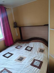 a bedroom with a bed with a wooden head board at Mobile homes a la ferme in Ille-sur-Têt