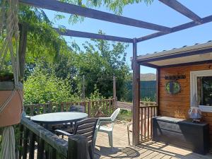 a patio with a table and chairs on a deck at Mobile homes a la ferme in Ille-sur-Têt +5 photos