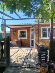 a house with a wooden deck with a porch at Mobile homes a la ferme in Ille-sur-Têt