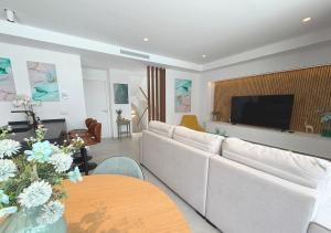 a living room with couches and a flat screen tv at LUXURY VILLA ALMENDRO 15 WITH PRIVATE HEATED POOL at SANTA ROSALIA RESORT by PREMIUM SPAIN PROPERTIES in Torre-Pacheco