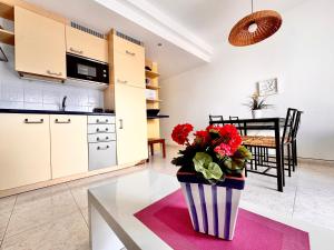 a kitchen and dining room with a vase of flowers on a table at Departamento Corriquia in Playa Blanca