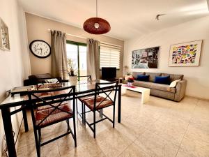 a living room with a table and chairs and a couch at Departamento Corriquia in Playa Blanca