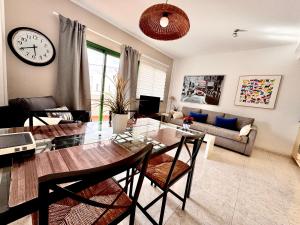 a living room with a dining table and a clock at Departamento Corriquia in Playa Blanca