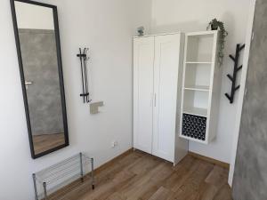 a room with a mirror and a white cabinet at Apartamenty Dana in Pustkowo +20 photos